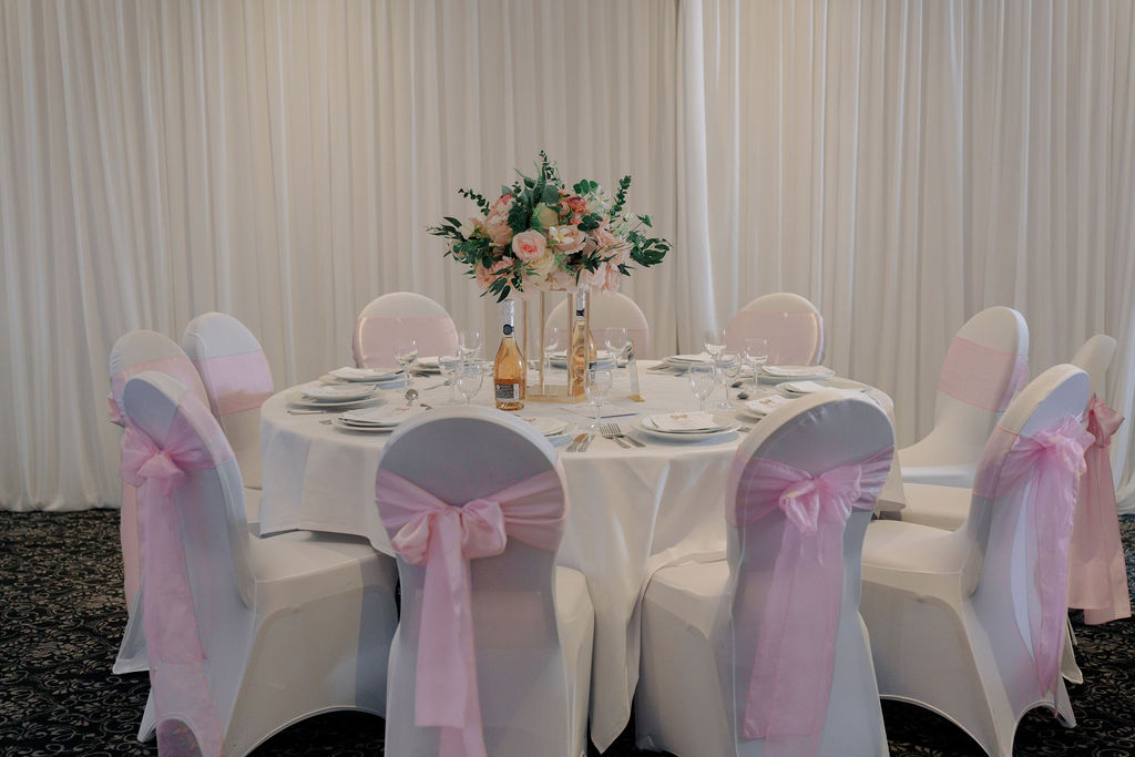 Elegant round table setting with pink sashes