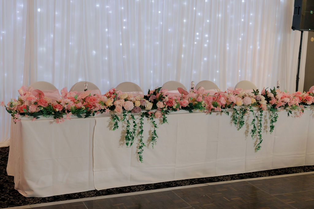 Head table with floral arrangement and fairy lights